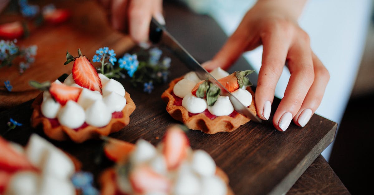 Why didn't my beer cake cook properly? - Crop woman cutting cake with berries