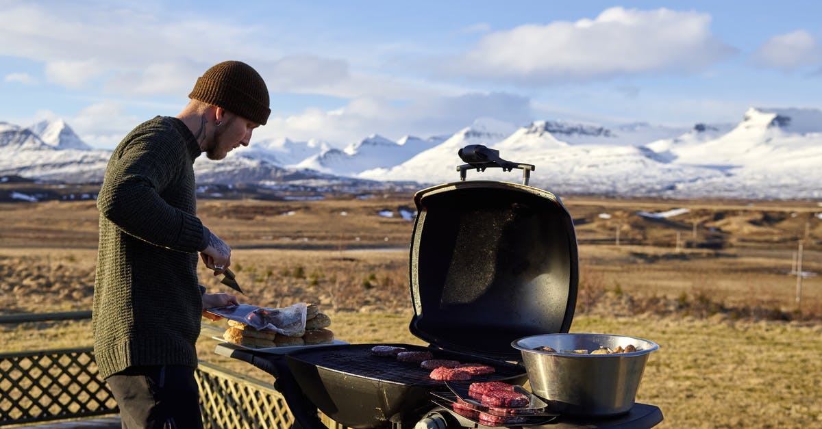 Why do burgers sometimes fall apart on the grill? - Young man grilling meat in camp