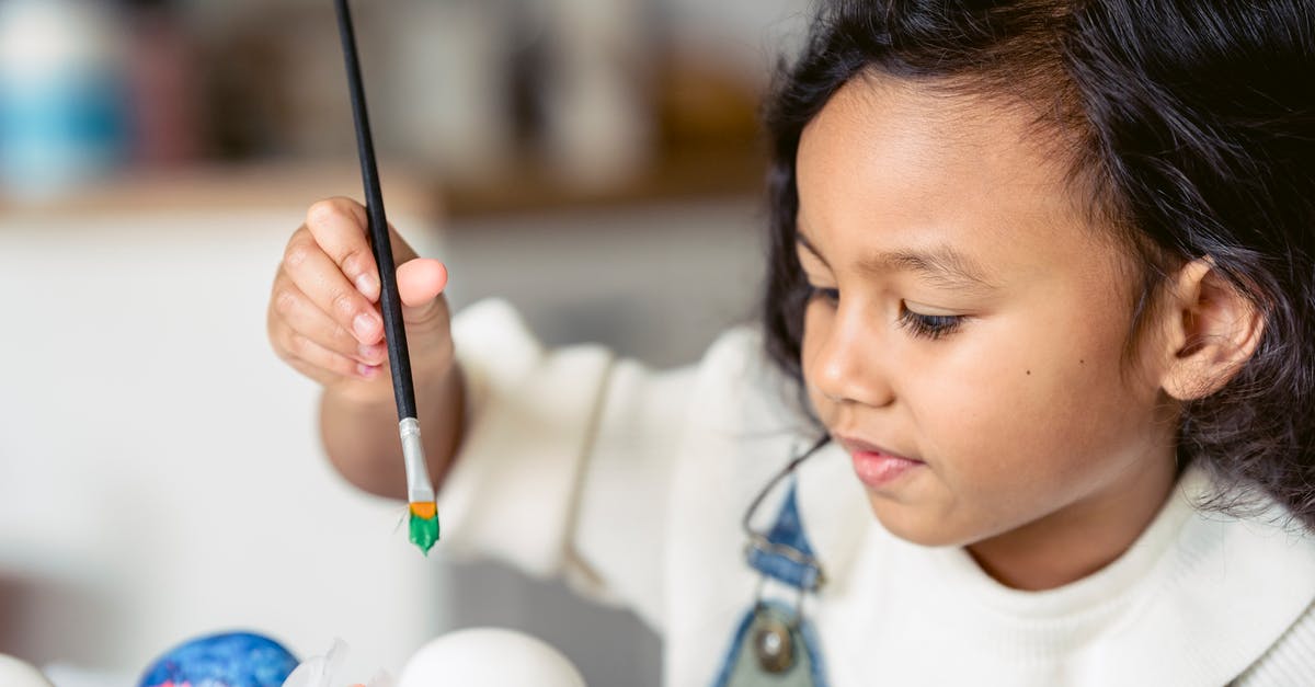 Why do egg dye recipes include vinegar? - Side view of concentrated Hispanic girl with paintbrush painting white eggs during Easter preparation in light room on blurred background