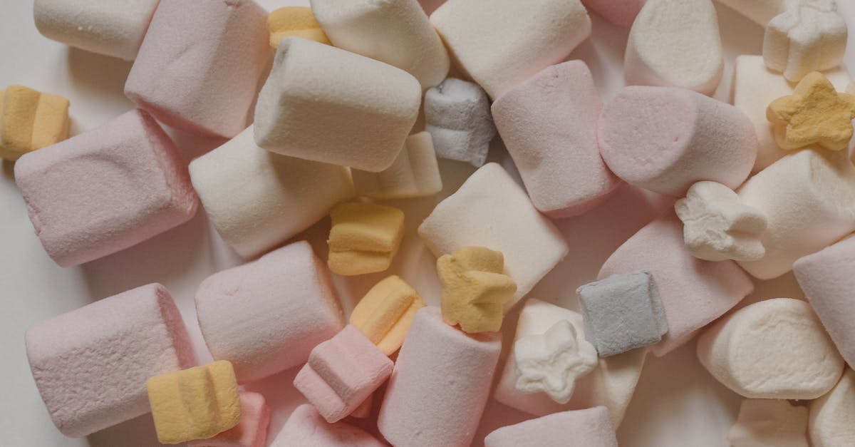 Why do grape-flavored foods taste different than actual grapes? - Top view arrangement of sweet delicious marshmallows of light color heaped on white surface