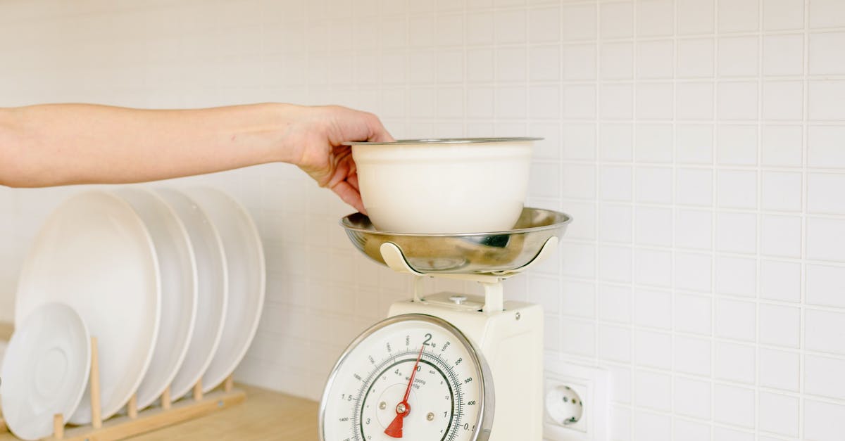 Why do my weighing scales have ml and g? - A Person Weighing the Ingredients on the Bowl