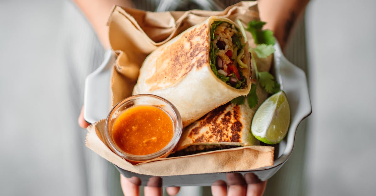 Why do people bury chili underground? - Person Holding Vegetable Tortilla Wrap with Dipping Sauce on the Side