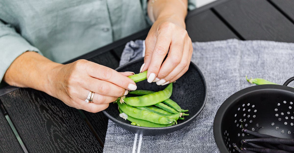 Why do purple snap beans turn green when cooked? - Person Holding Green Vegetable on Black Round Plate