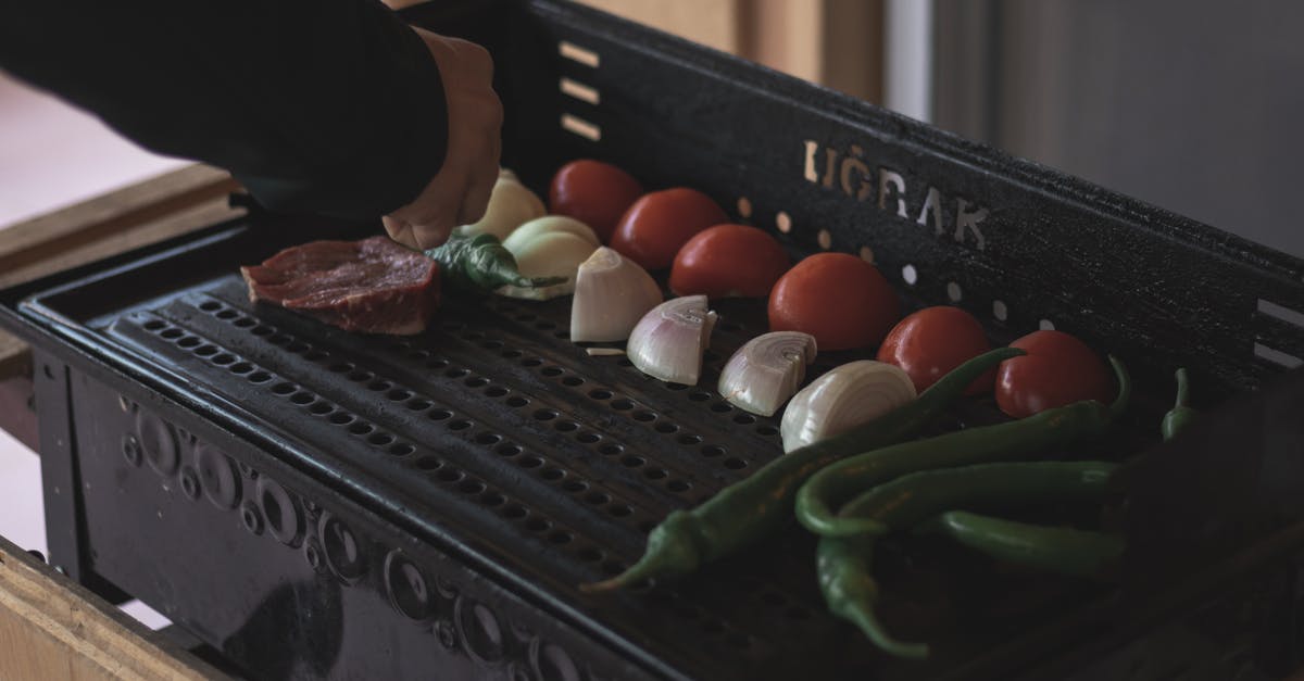 Why do you marinade steak with onions? - Person Grilling Beef with Onions and Tomatoes 