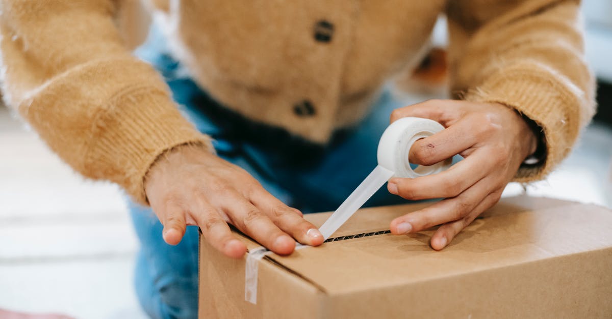 Why do you need to wrap containers of brined meat? - Crop unrecognizable woman sealing carton parcel with tape