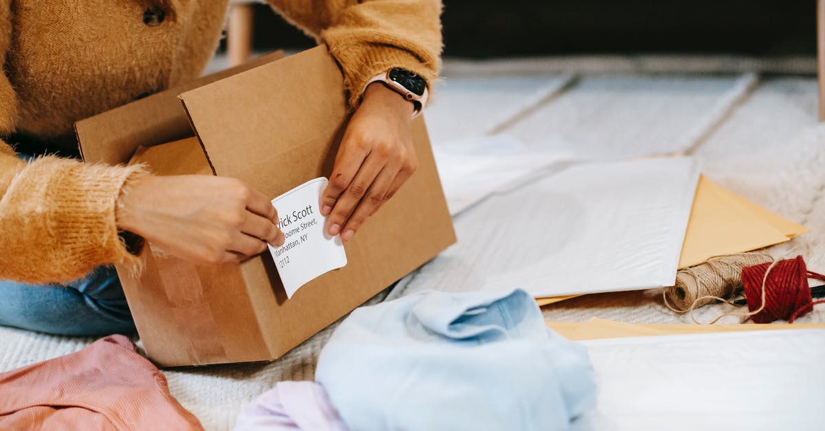 Why do you need to wrap containers of brined meat? - Crop unrecognizable woman sticking shipping label on parcel