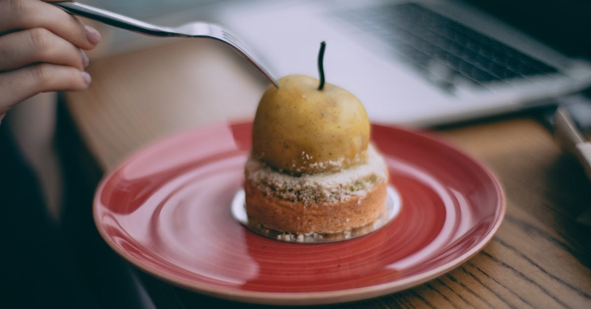 Why do you use sugar when canning peaches or pears? - Crop anonymous female with fork enjoying yummy fresh peach dessert while sitting at table with laptop