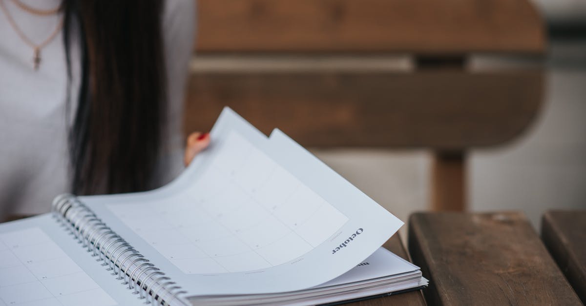 Why does a white sauce (bechamel,veloute) sometimes turn grey? - Crop unrecognizable female student with dark hair in white blouse turning pages of notepad at wooden table in park