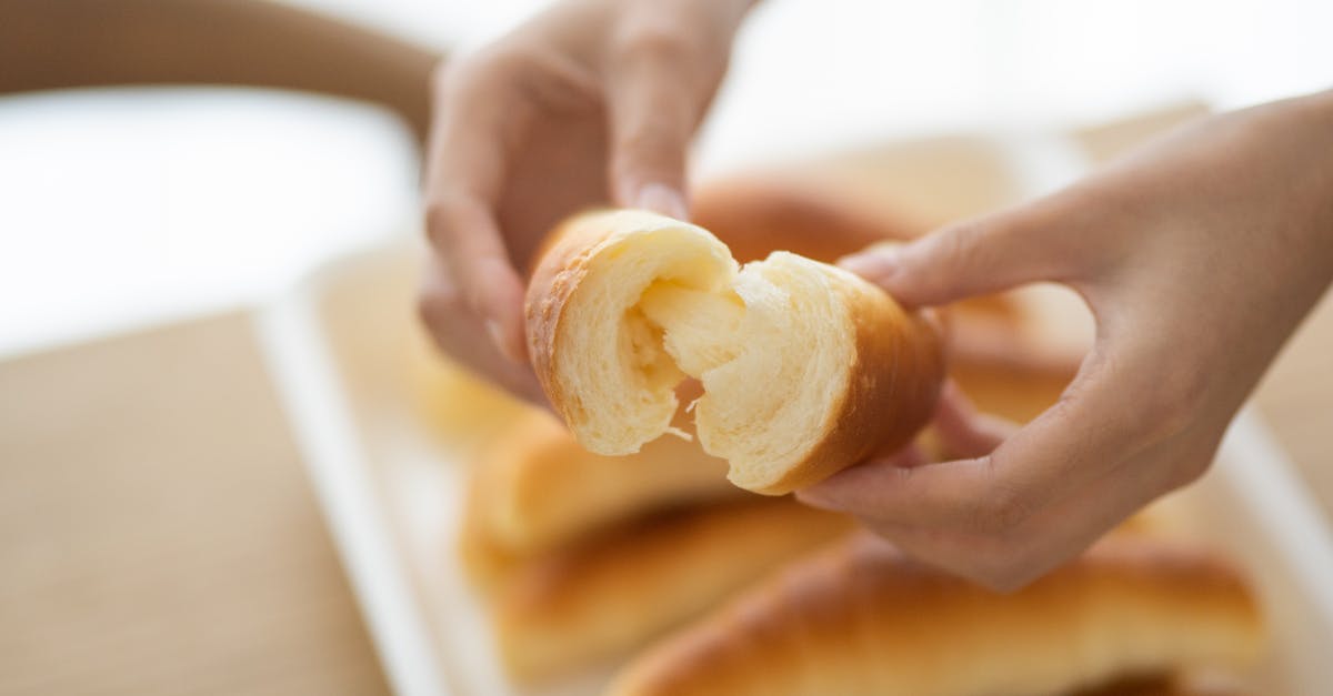 Why does bread soften after heating it up? - Person Holding a Bread With White Cream