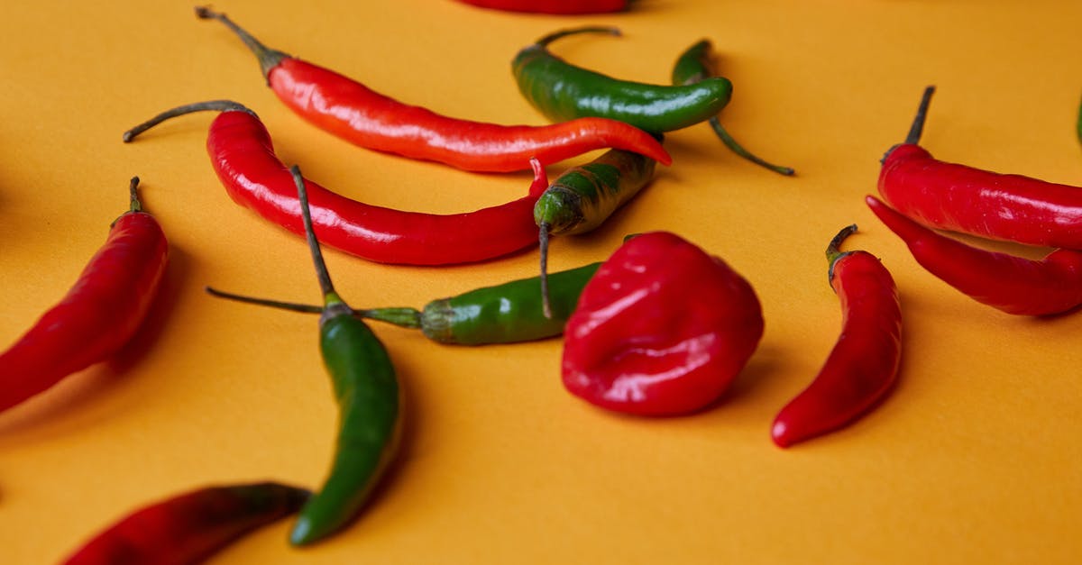 Why does food cook differently in a double-boiler? - Red and green chili peppers scattered on yellow surface