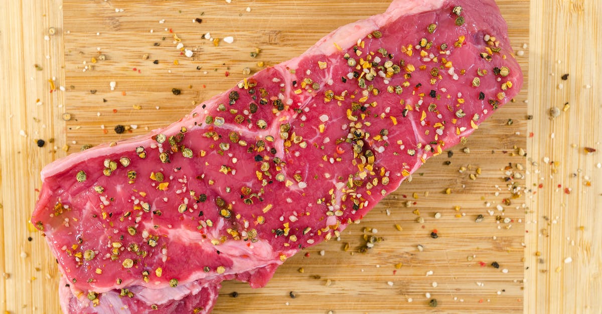 Why does meat (beef and pork) stay pink inside even when braised or stewed for hours? - Raw Meat on Beige Wooden Surface Why does meat (beef and pork) stay pink inside even when braised or stewed for hours? - Raw Meat on Beige Wooden Surface