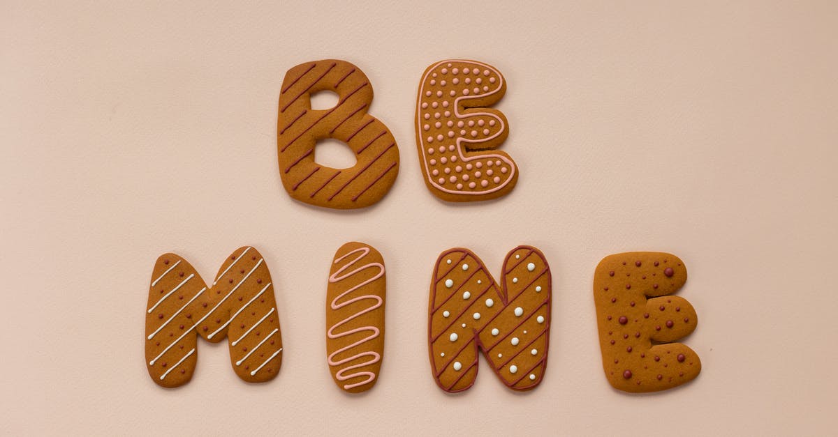 Why does my baked custard form a skin on it? - Top view of delicious cookies forming Be Mine phrase placed on beige background during celebration of romantic Saint Valentine Day