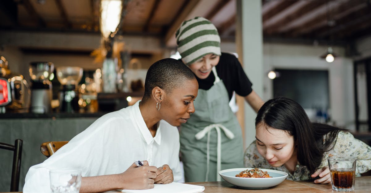 Why does my canned enchilada sauce smell and taste like dog food? - Cheerful coworkers tasting and smelling food in restaurant Why does my canned enchilada sauce smell and taste like dog food? - Cheerful coworkers tasting and smelling food in restaurant