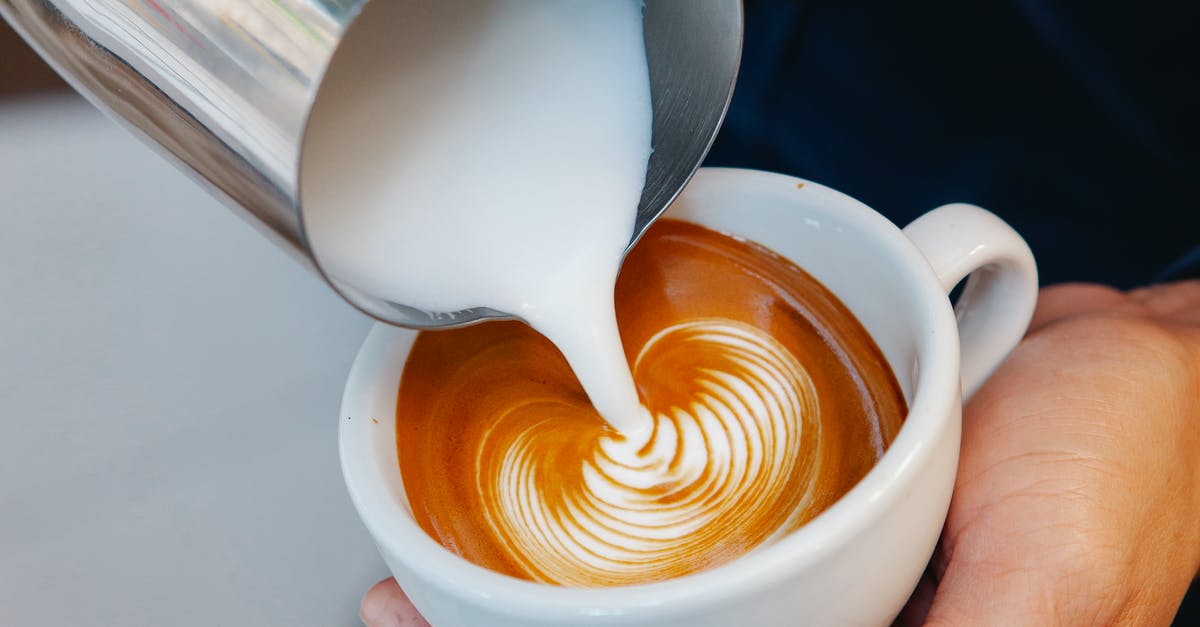 why does my non dairy creamer not dissolve in coffee? - Crop unrecognizable male cafe worker pouring fresh milk from pitcher into aromatic coffee with foam