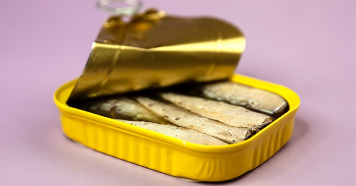 Why does processed meat contain preservatives, while canned fish needs not? - Opened delicious canned sardines in yellow container with oil on centre of light purple background