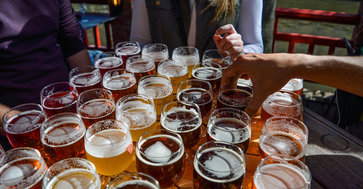 why does toast smell and taste different than bread? - High angle of crop faceless friends tasting various types of craft beer while relaxing together in street cafe on sunny day