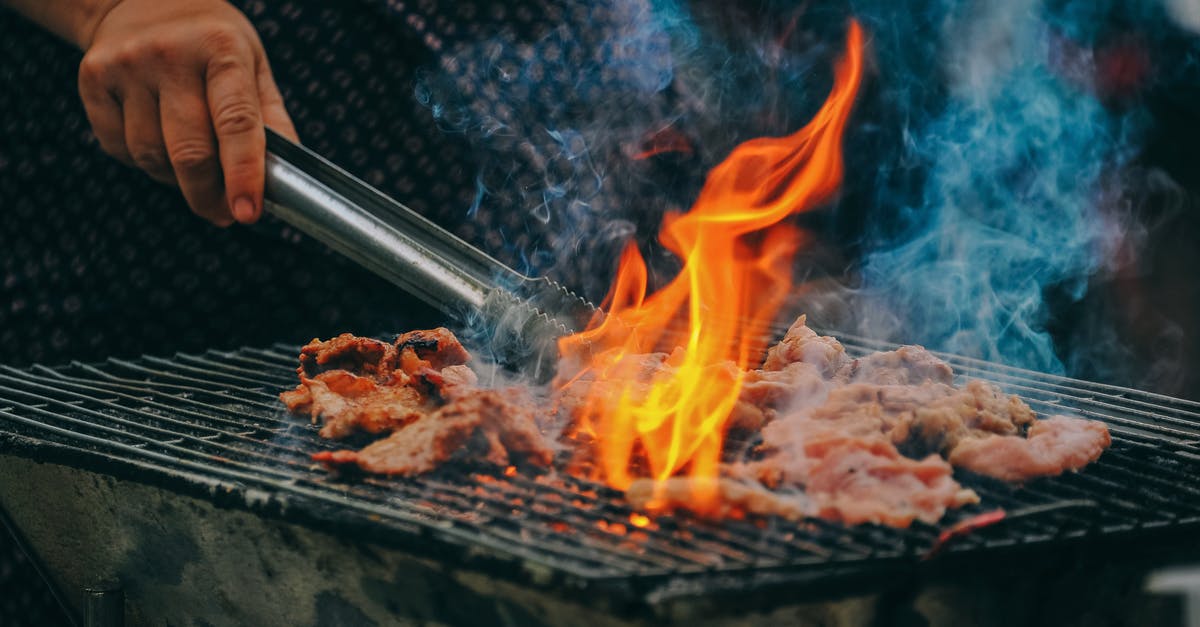 Why doesn't oil burn and produce smoke at restaurants? - Close-Up Photo of Man Cooking Meat