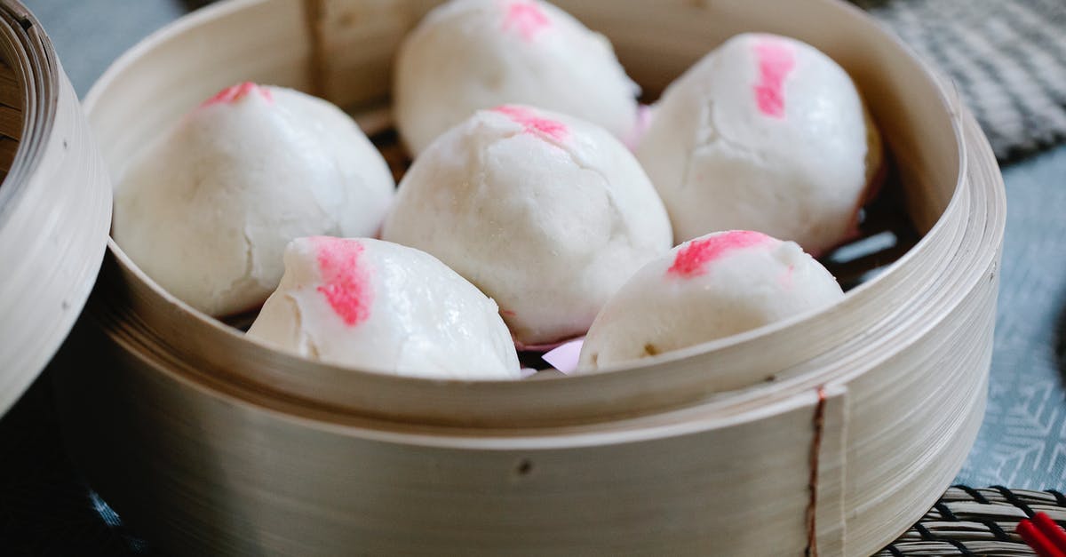 Why don't filled doughnuts have compressed dough around the filling? - From above of raw Chinese homemade bao in bamboo steamer prepared for traditional lunch