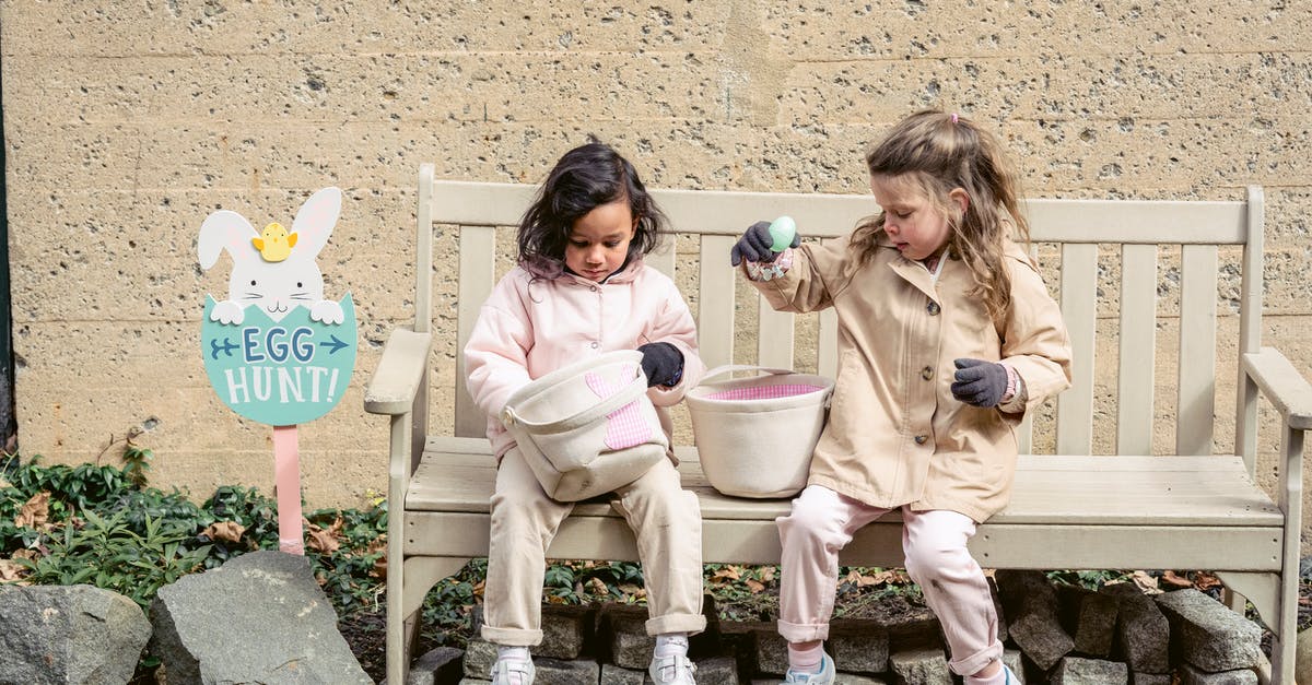 Why don't I have to season my cast-iron teapot? - Full body positive cute diverse girls in warm clothes playing with Easter eggs and sitting on bench in backyard