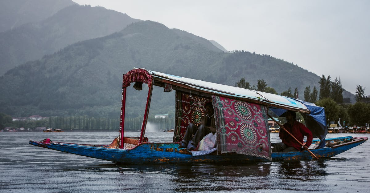 Why fry a teaspoon of dal to start an Indian dish? - Anonymous ethnic men in roofed boat on lake against ridge