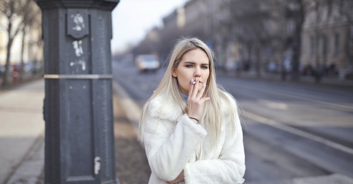 Why has my cold smoking stopped working? - Selective Focus Photo of Woman in White Coat Standing by the Road Smoking a Cigarette