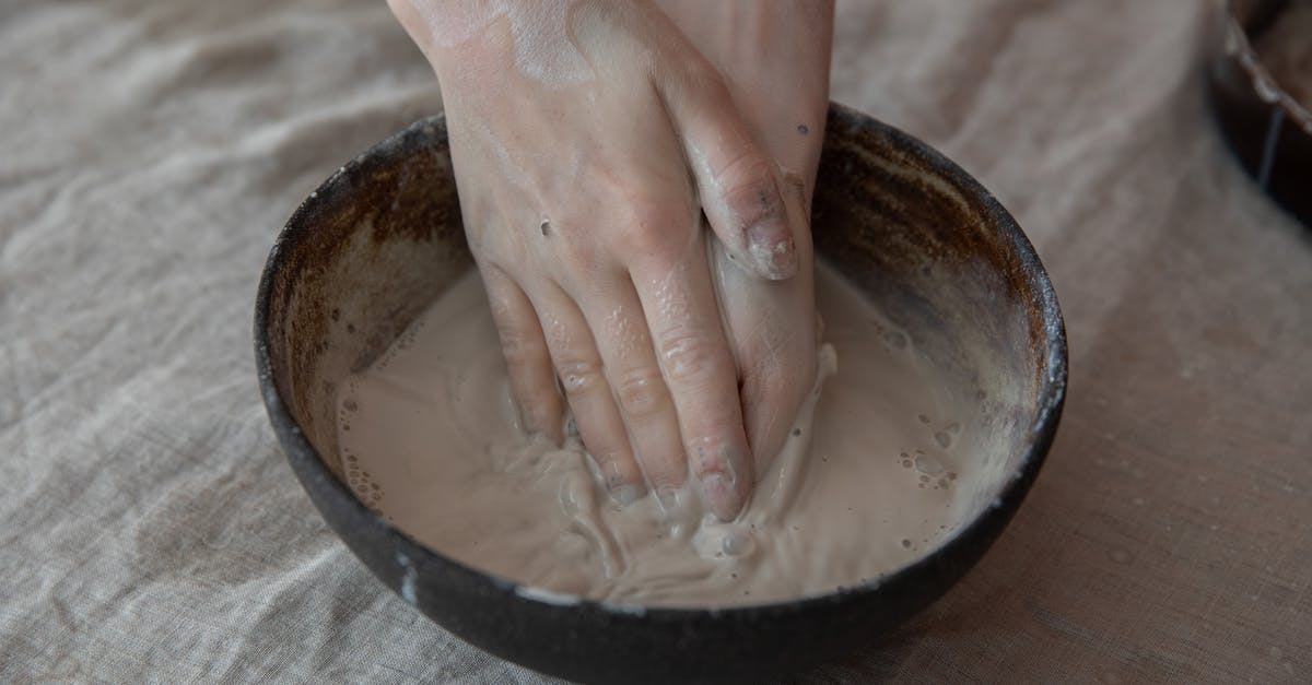 Why has my recently bought peanut butter such a liquid consistency? - From above of crop anonymous craftsperson mixing clay in round shaped bowl in workroom