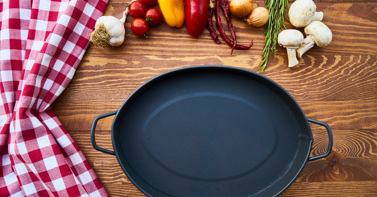 Why is acidic cooking problematic for cast iron pans but not BBQ plates? - Cast Iron Skillet on Table With Species Why is acidic cooking problematic for cast iron pans but not BBQ plates? - Cast Iron Skillet on Table With Species