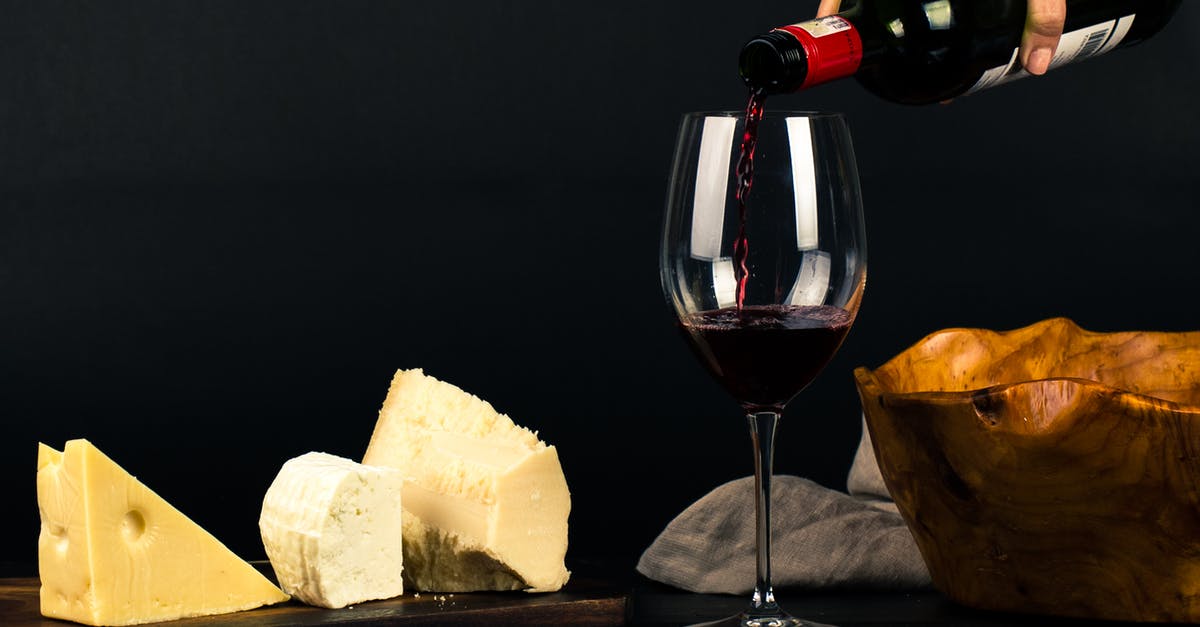 Why is cheese wax red? - Photo of Person Pouring Wine into Glass besides Some Cheese Pairings