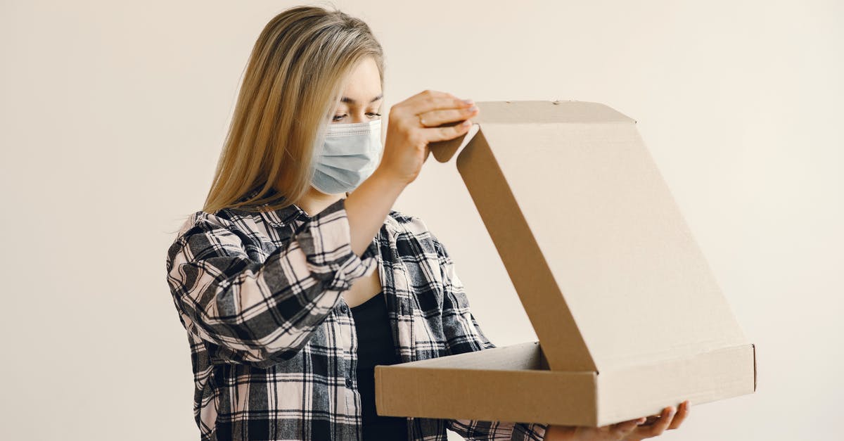 Why is delivered pizza often oily? - Young woman in medical mask opening pizza box