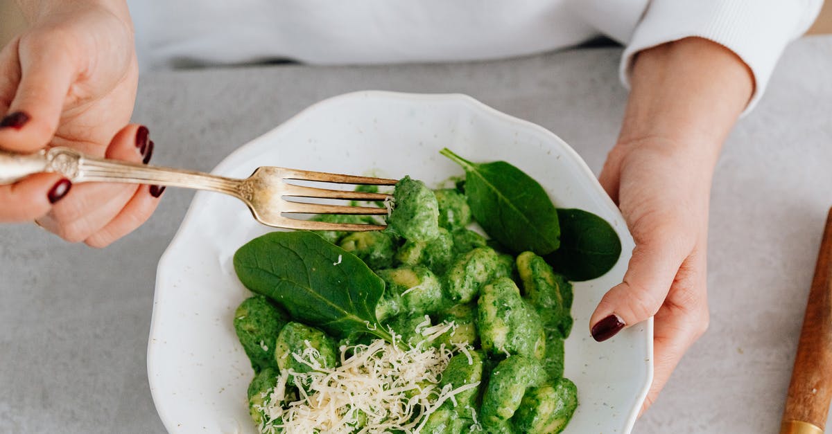 Why is gnocchi a dumpling and not a noodle? - A Person Holding a Ceramic Plate and Fork with Gnocchi