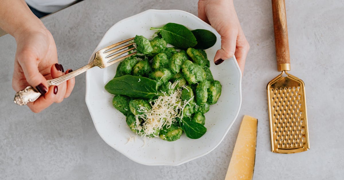 Why is gnocchi a dumpling and not a noodle? - A Person Holding a Plate and a Fork with Green Food