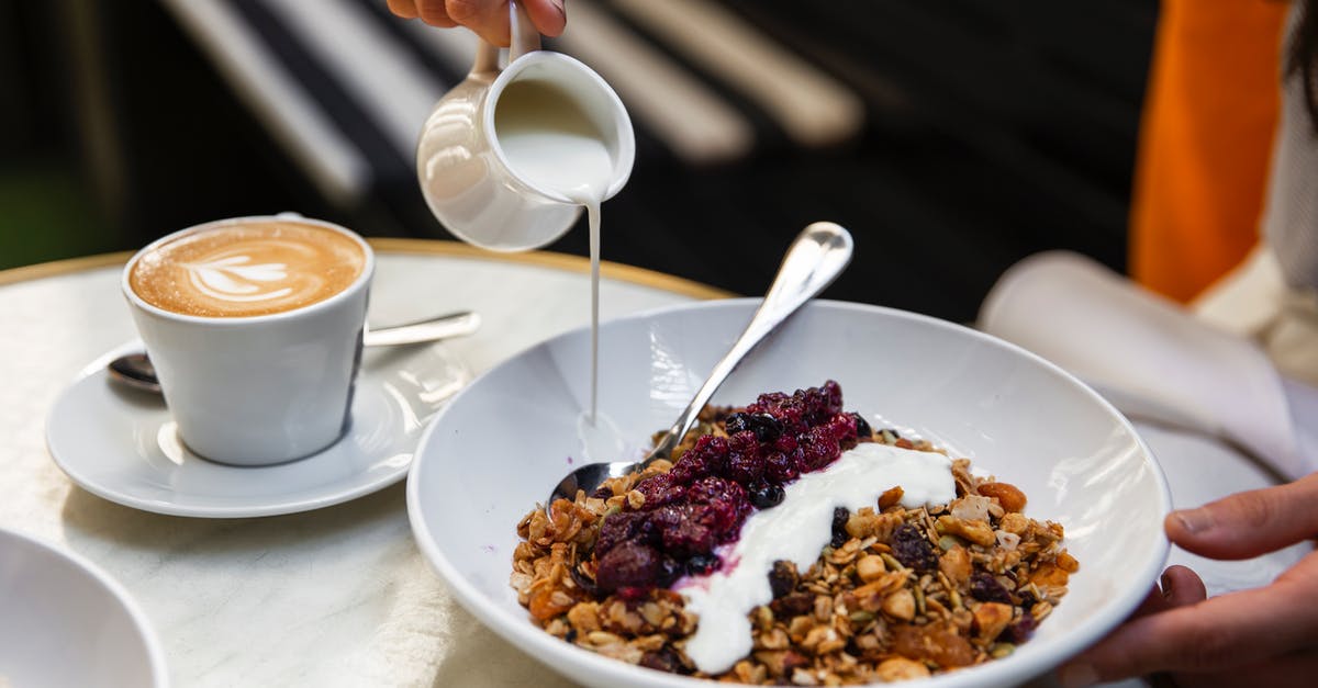 Why is it recommended to mix yogurt starter with a small amount of milk before adding to the entire batch? - Unrecognizable person having breakfast at table with coffee and muesli Why is it recommended to mix yogurt starter with a small amount of milk before adding to the entire batch? - Unrecognizable person having breakfast at table with coffee and muesli