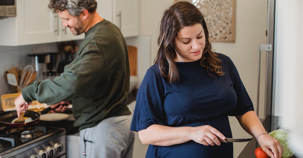 Why is lettuce rarely cooked? - Cheerful couple cooking dinner in kitchen