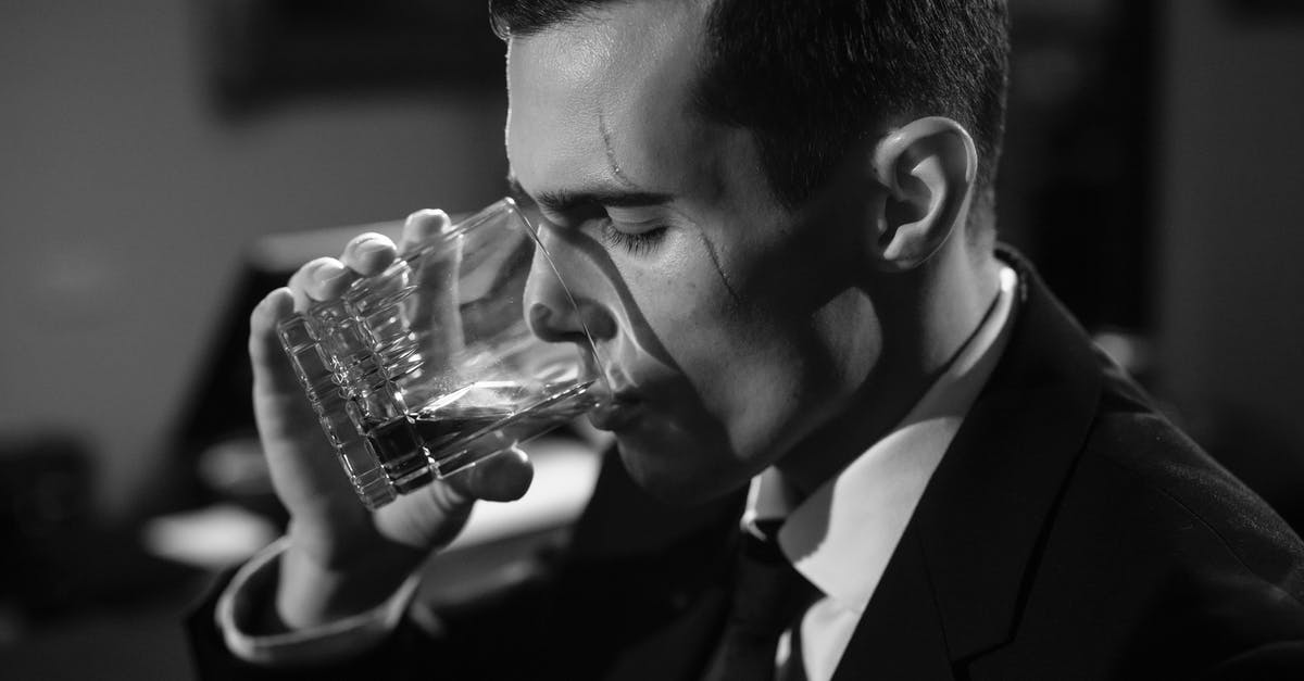 Why is mixing good whiskey with cola/ginger ale frowned upon? [closed] - Close-Up Photo of Man Drinking Whiskey