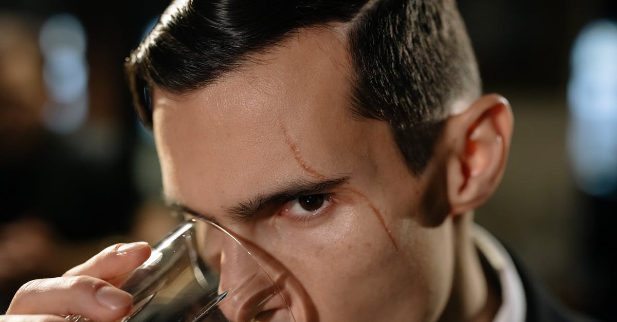 Why is mixing good whiskey with cola/ginger ale frowned upon? [closed] - Close-Up Photo of Man Drinking from Glass of Whiskey