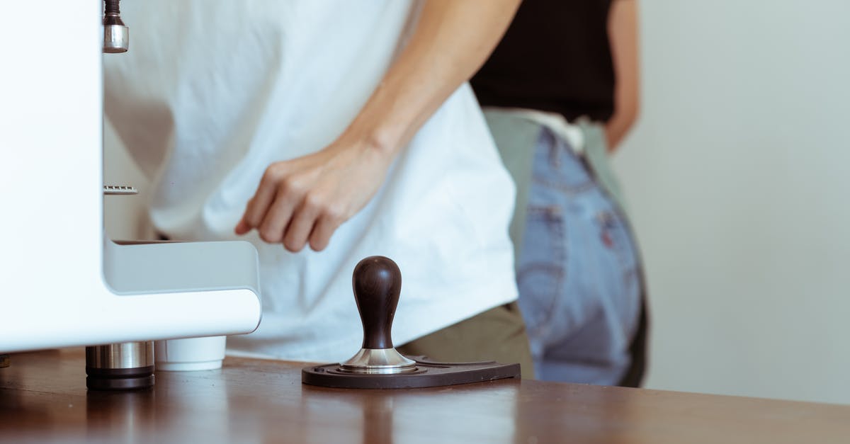 Why isn't my espresso coffee nice and strong? - Crop cafe workers at table with coffeemaker and tamper