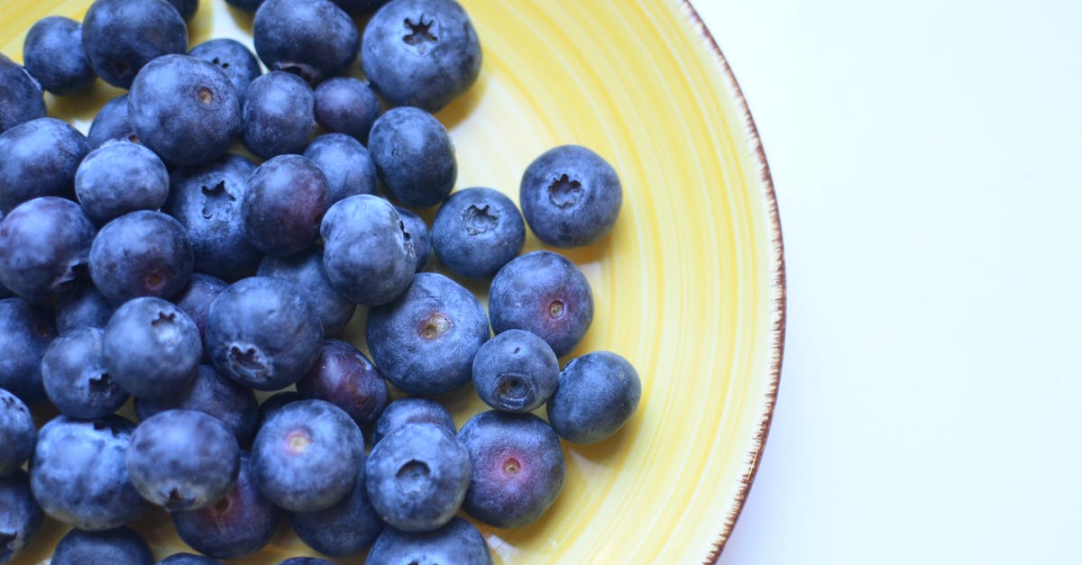 why pepitas (pumpkin seeds) taste like blue cheese? - Top view of natural juicy blueberry with sweet taste on yellow ceramic plate