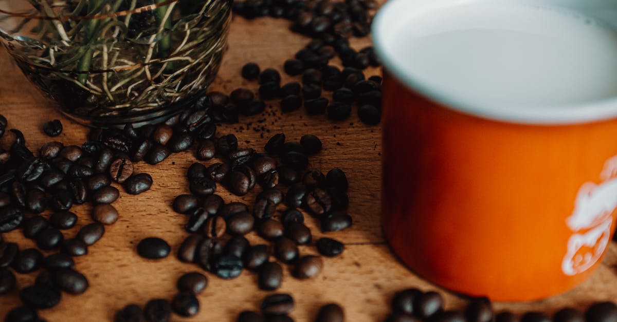 Why re-boiling milk doesn't boil over again? - Cup of coffee with beans on table