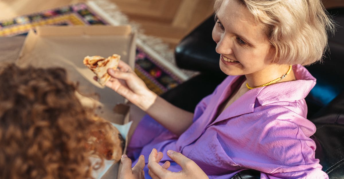 Why the pizza is able to "recover" so quickly? - Woman in Purple Button Up Shirt Holding Brown Bread