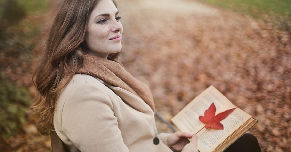 Why throw away so much sourdough starter? Tartine Book no. 3 - Side view of peaceful young female in warm coat and scarf sitting on bench with open book in hands and looking away pensively while resting in autumn park