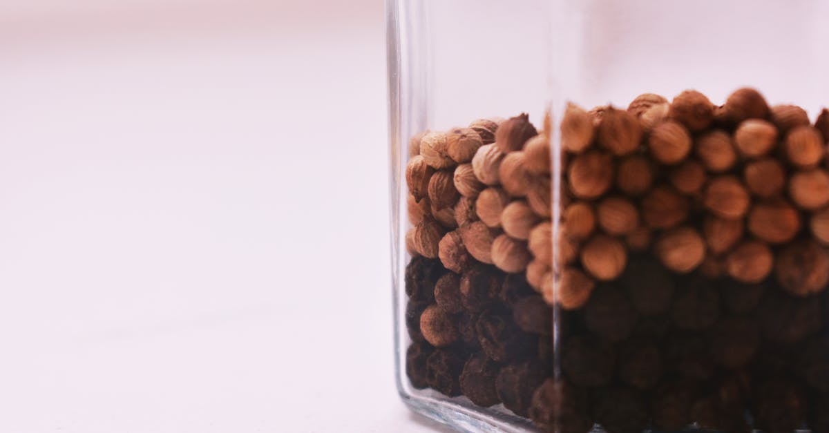 Why whole peppercorns? - Selective Focus Photography of Peppercorns Inside Glass Container on White Surface
