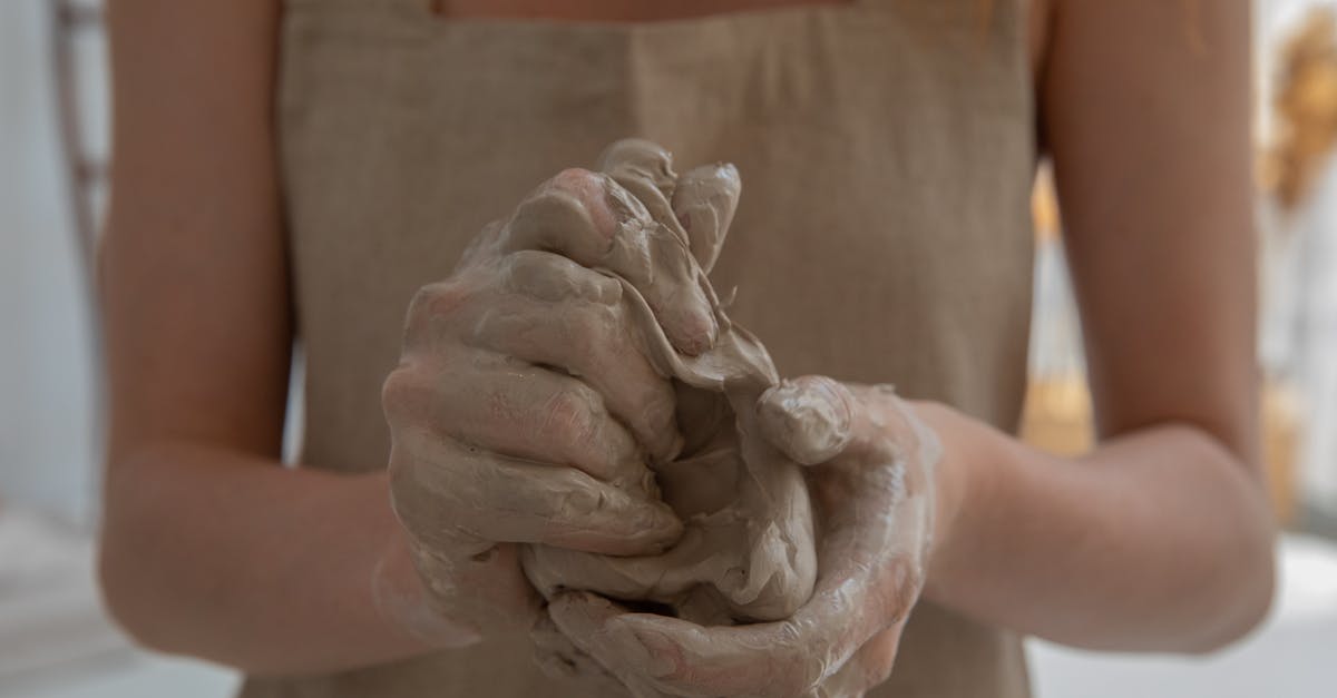 Why won't my sourdough form a shapeable dough that doesn't stick? - Crop faceless woman kneading clay in workshop