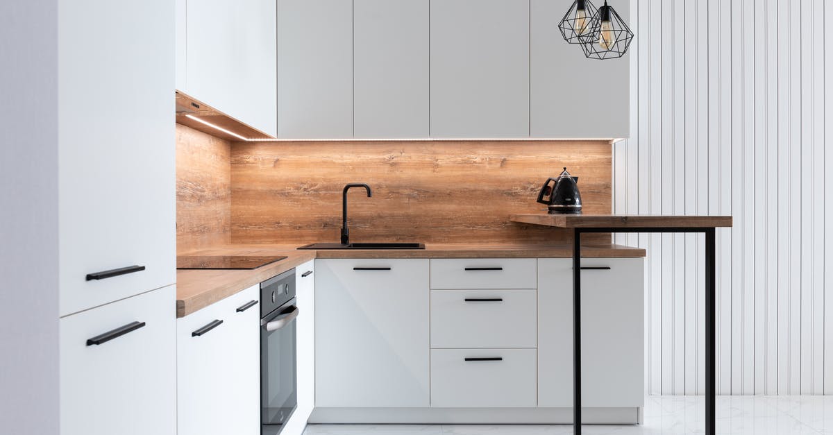 Why would boiling milk in an electric kettle break the kettle? - Contemporary interior of modern kitchen with comfortable white furniture and geometrical lamps hanging on ceiling