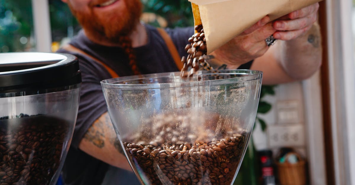 Will roasted corn work as soup croutons? - Crop content hipster employee pouring coffee beans into grinder