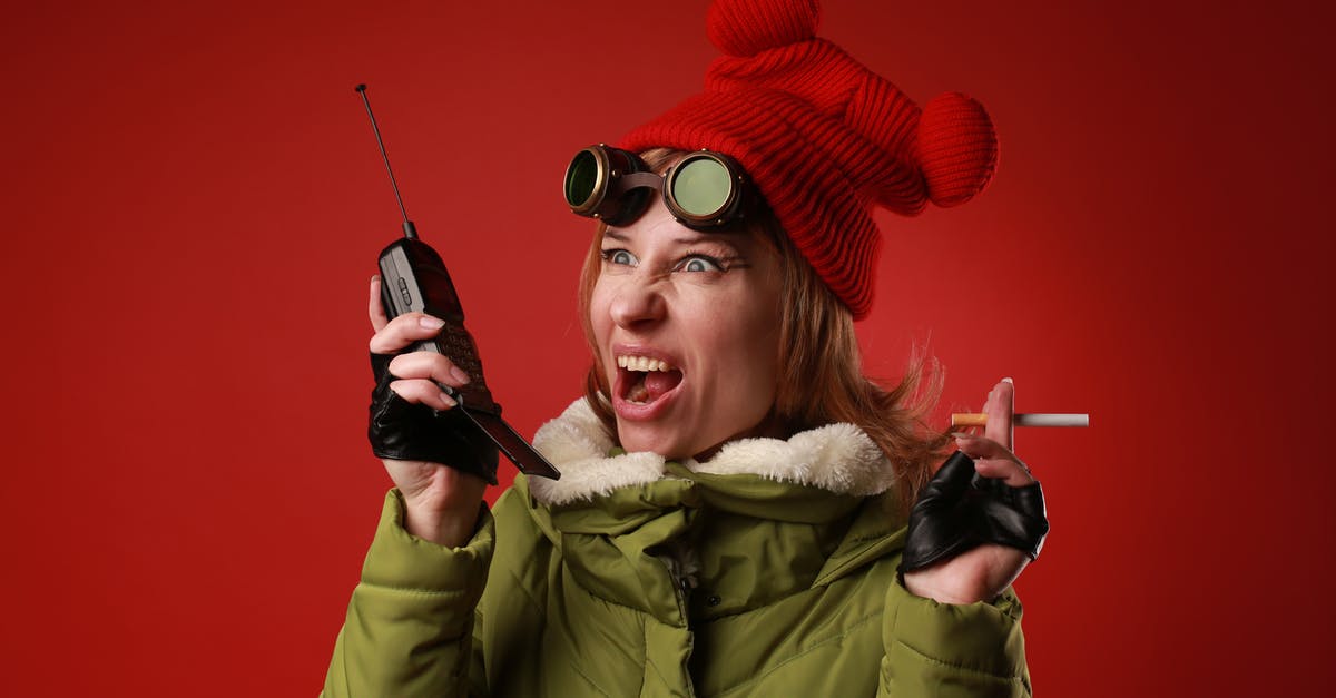 Will using 4 year old unsalted butter make one sick? - Annoyed female model in outerwear with old goggles yelling into walkie talkie while looking away on red background