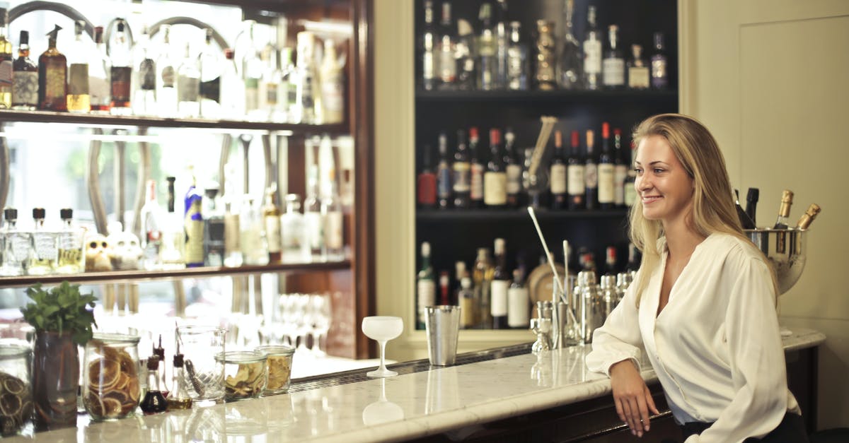 Wine sediment clinging to top of bottle? - Woman in White Long Sleeve Leaning In Counter Table