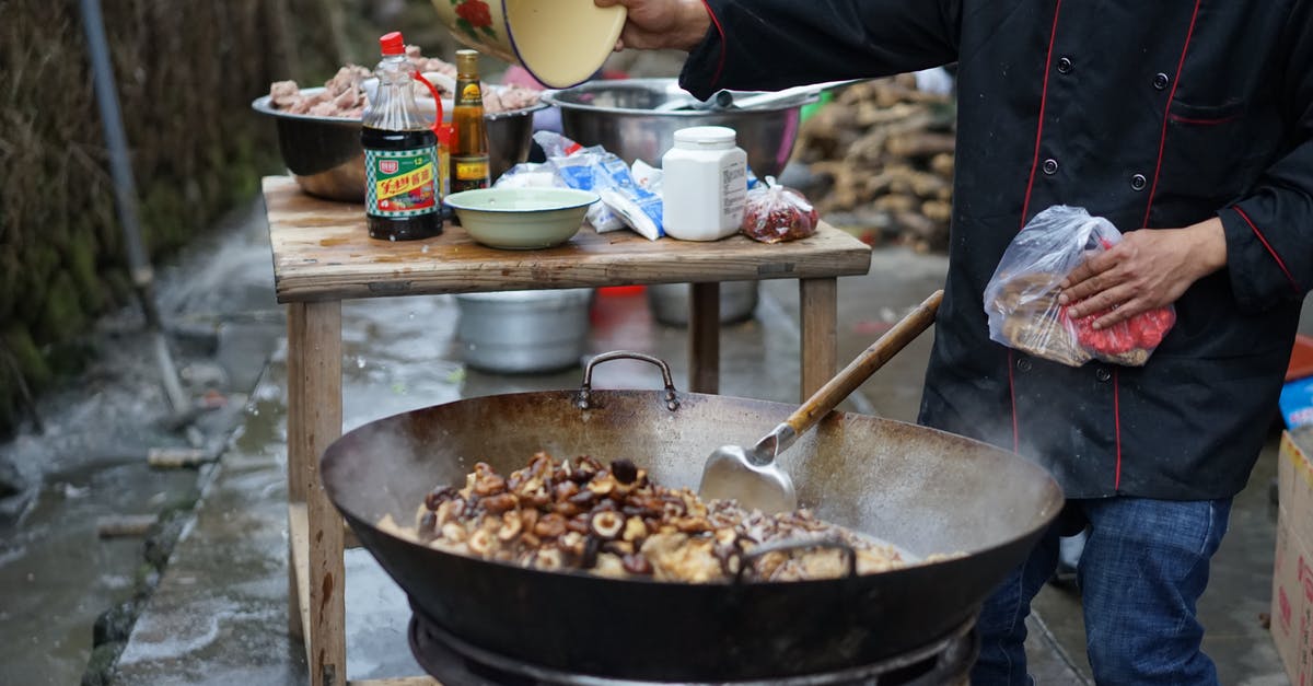 Wok patina; when to redo seasoning? - Person Cooking Mushrooms in a Wok