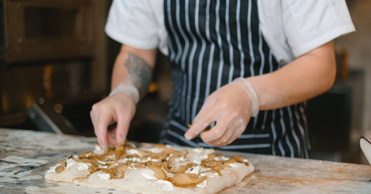 Working with sticky dough for pizza making - A Chef Putting the Pizza Toppings