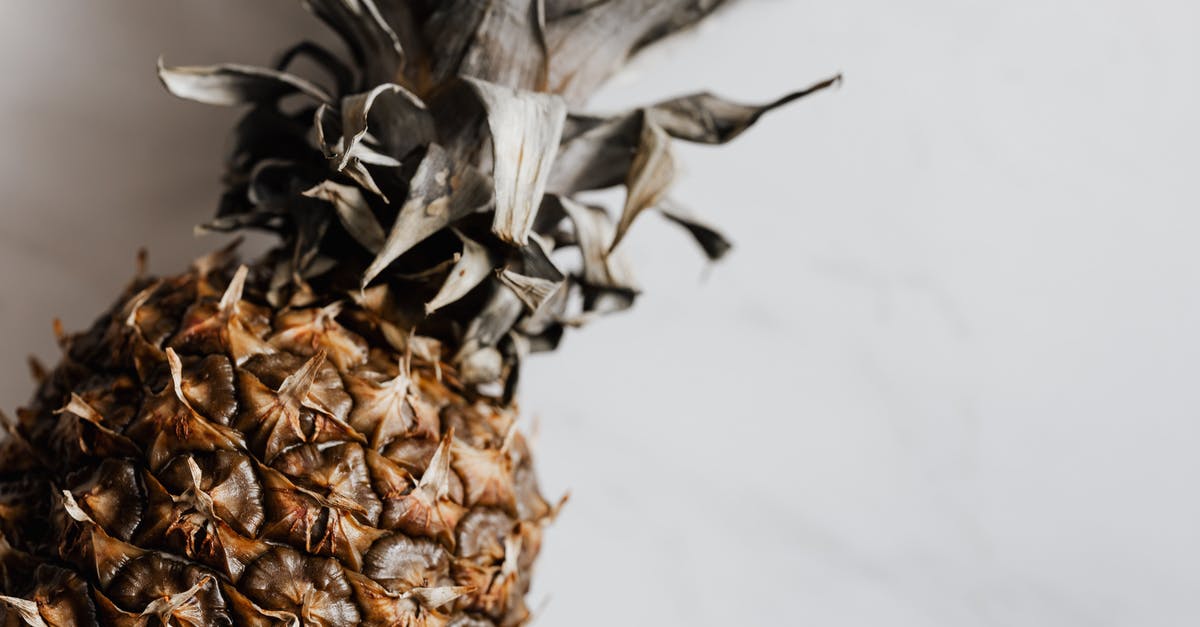 Would freezing a whole pineapple change it visually? - From above of fresh whole ripe pineapple placed on white marble texture pattern