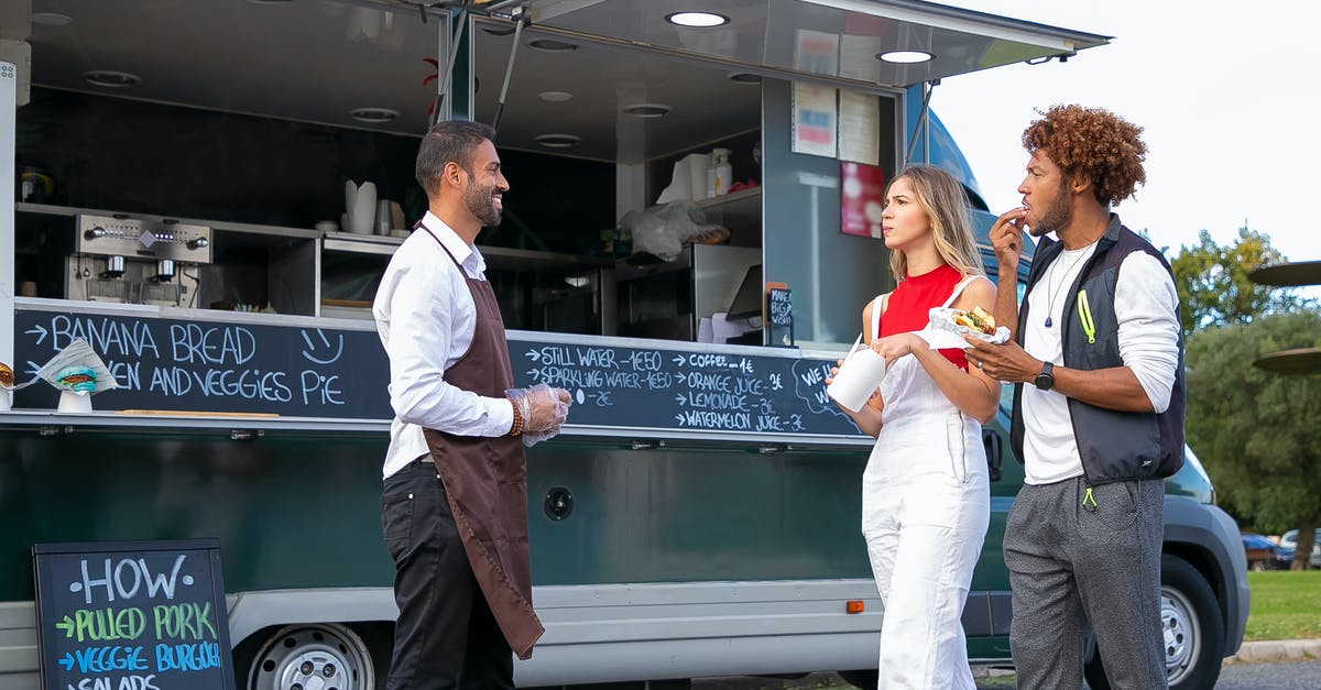 Would it be advisable to partially pre-grill hamburgers and freeze so that they can be pan fried when a customer orders? - Side view of happy young ethnic waiter in uniform standing near food van and smiling while greeting diverse customers eating delicious takeaway burger and french fries Would it be advisable to partially pre-grill hamburgers and freeze so that they can be pan fried when a customer orders? - Side view of happy young ethnic waiter in uniform standing near food van and smiling while greeting diverse customers eating delicious takeaway burger and french fries